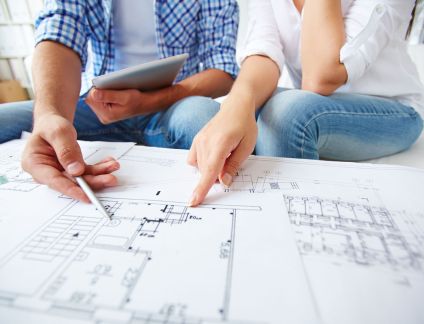 Jeune couple avec plan architecte pour projet immobilier