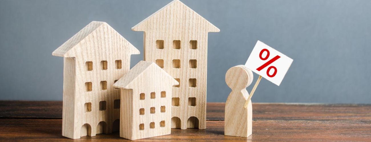 3 petites maisons en bois et un petit homme sur un bureau en bois